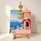 Vibrant Mediterranean seaside cottage hand-painted artwork with yellow shutters, bougainvillea flowers, blue sea and a sailing boat