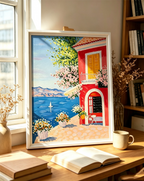 Hand-painted Mediterranean coastal artwork featuring a colorful seaside cottage, blue ocean, flowers and distant mountains